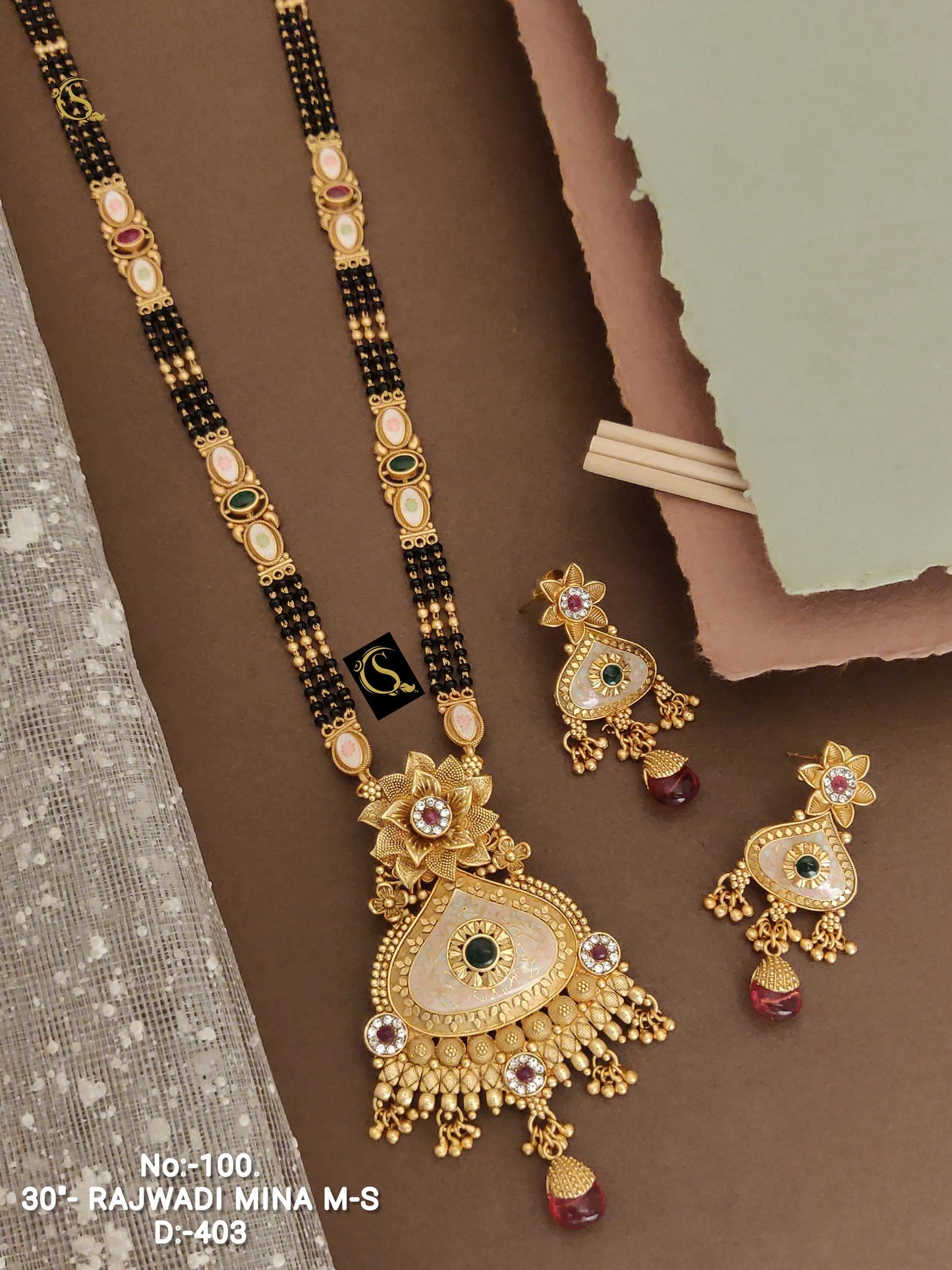 Traditional Rajwadi Mina necklace and matching earrings with gold finish and intricate design on brown background