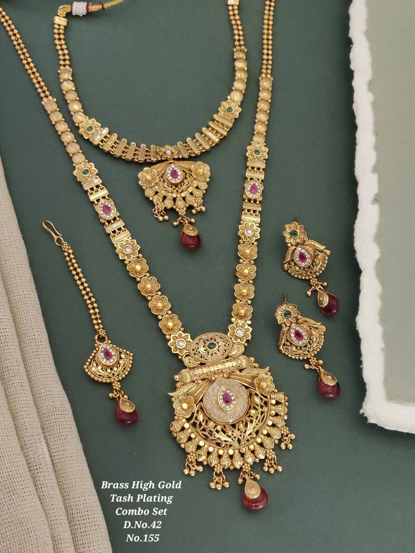Brass high gold plating jewelry set with red and green stones on green background
