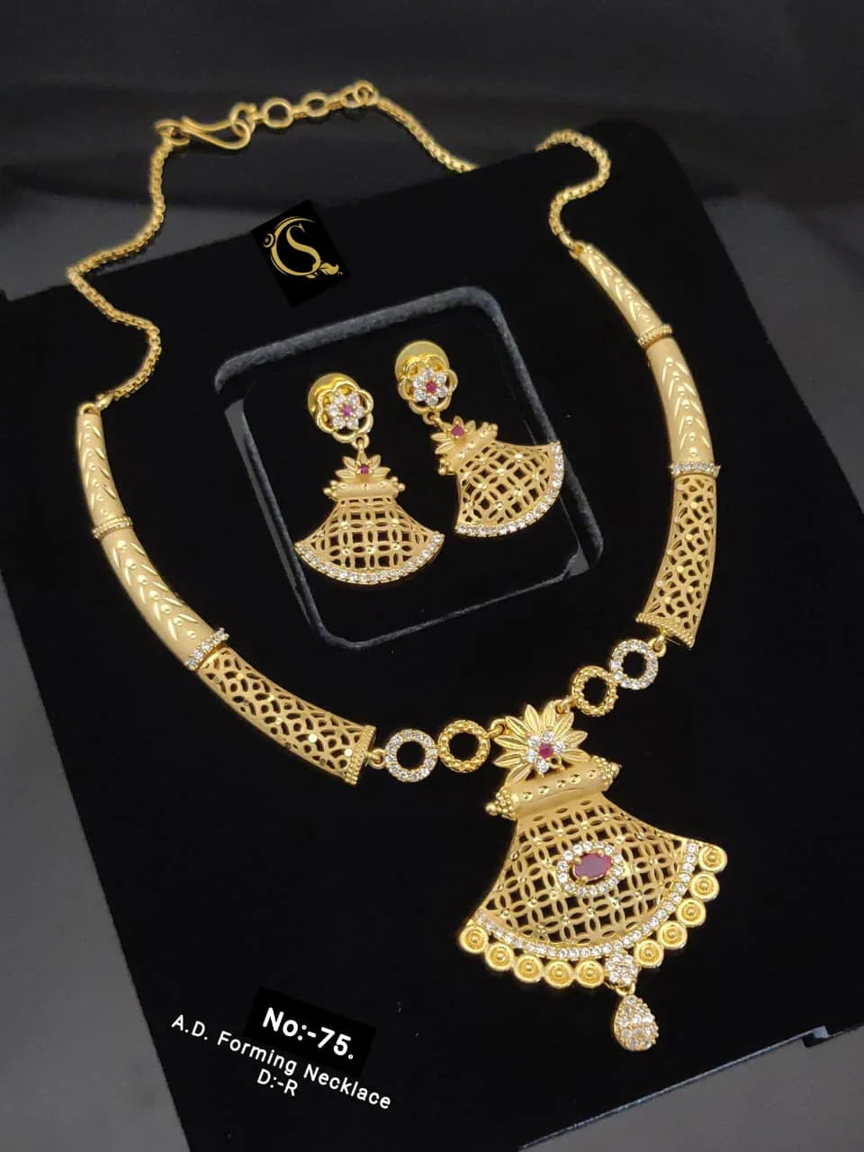 Gold A.D. forming necklace and matching earrings set with intricate lattice design and pink gemstone accents