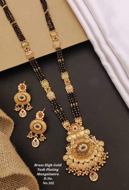 Brass high gold plated mangalsutra with black beads and matching earrings on black and beige background