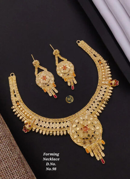 Intricate gold necklace and matching earrings set on black background, traditional floral design